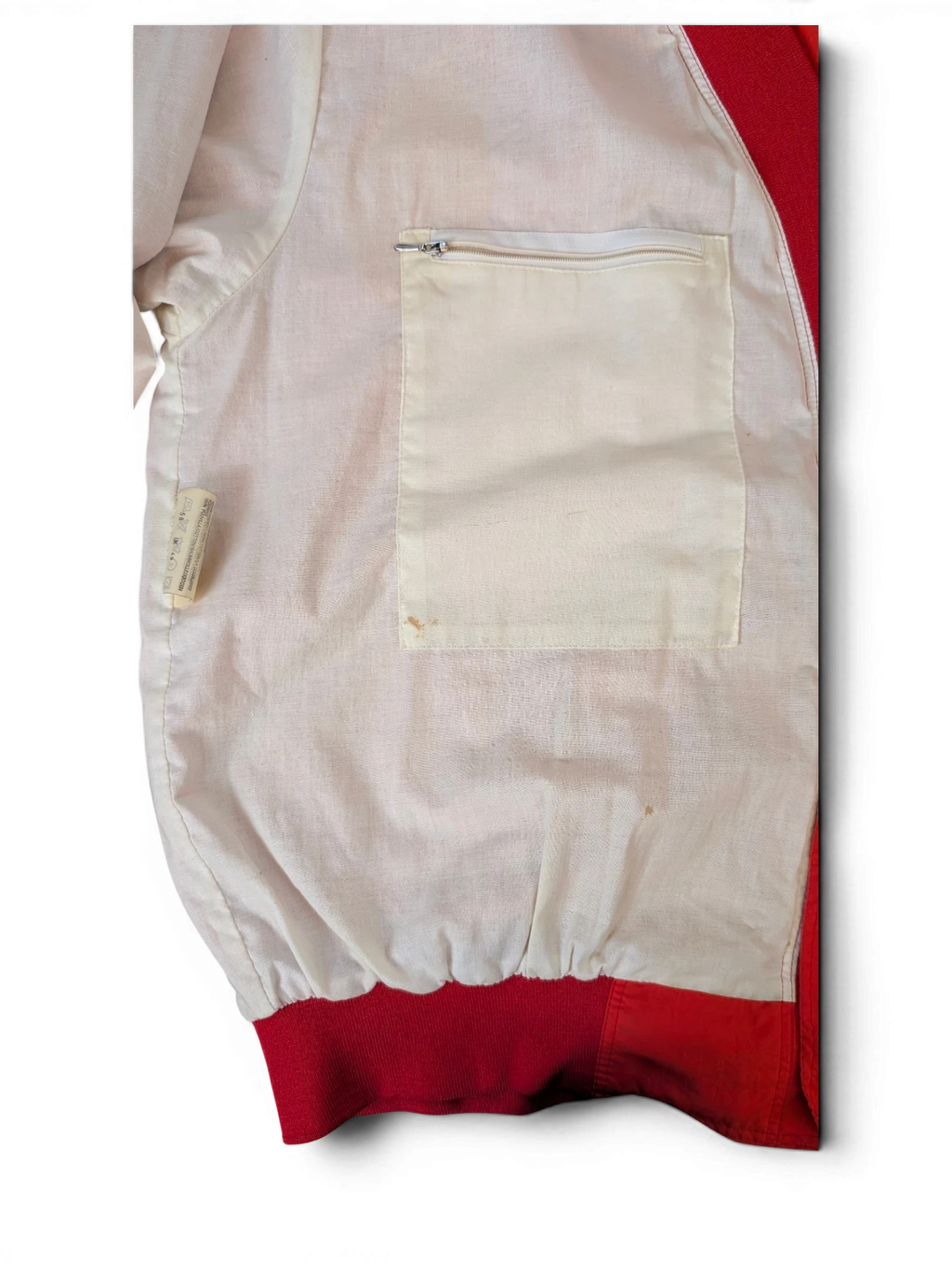 Interior view of a JAKE & IPI Toyota club jacket featuring a white lining, red trim, and a zippered chest pocket.