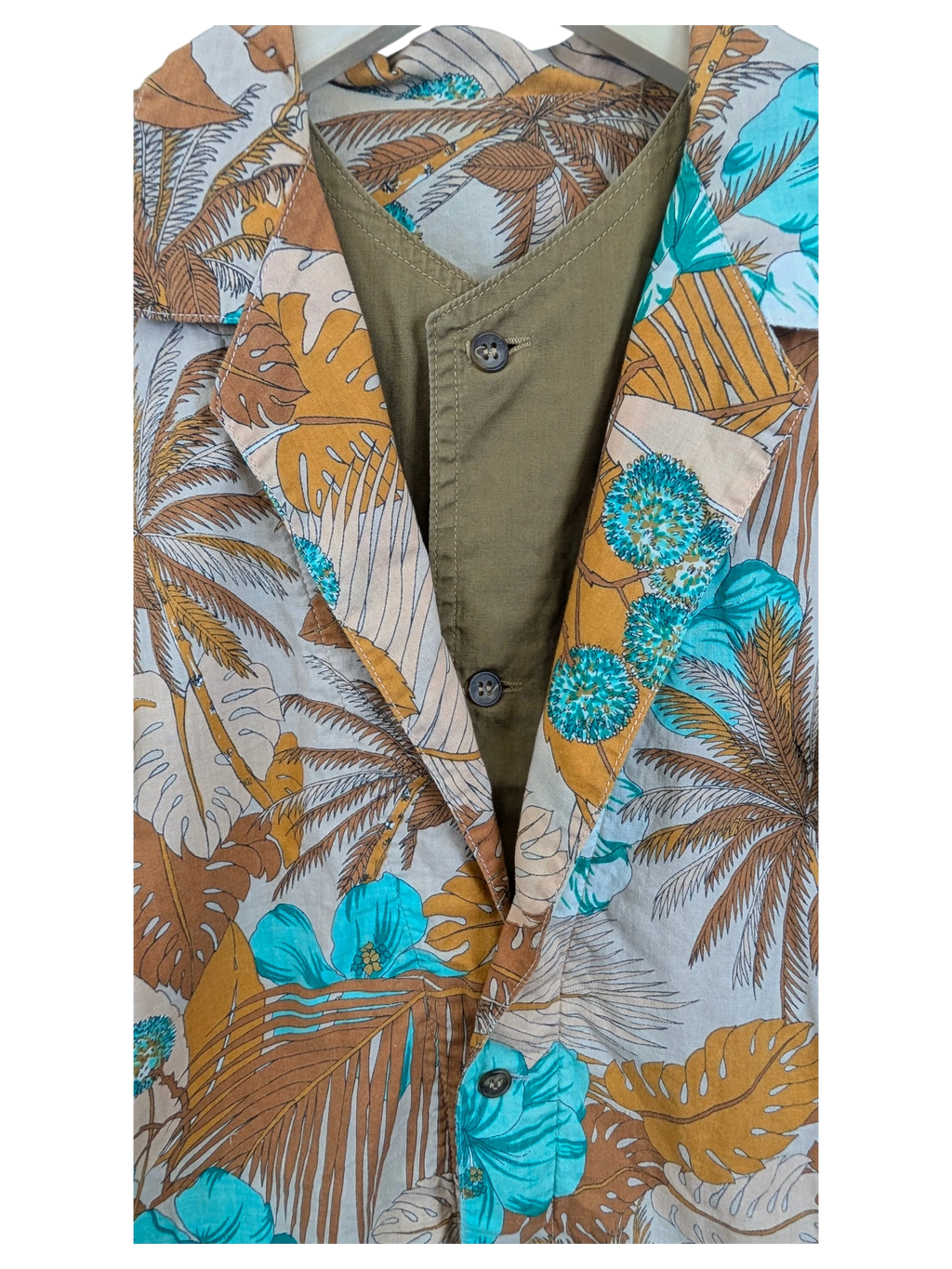 JAKE & IPI Hawaiian shirt featuring a tropical palm leaf and hibiscus print in teal and brown over an olive base.