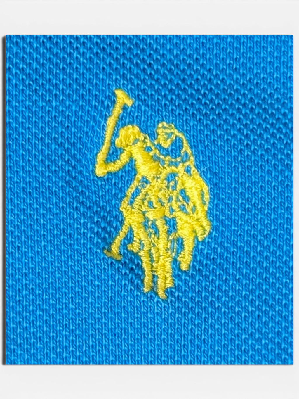 JAKE & IPI pre-owned turquoise U.S. Polo Assn. polo shirt with a yellow embroidered player logo on the chest.
