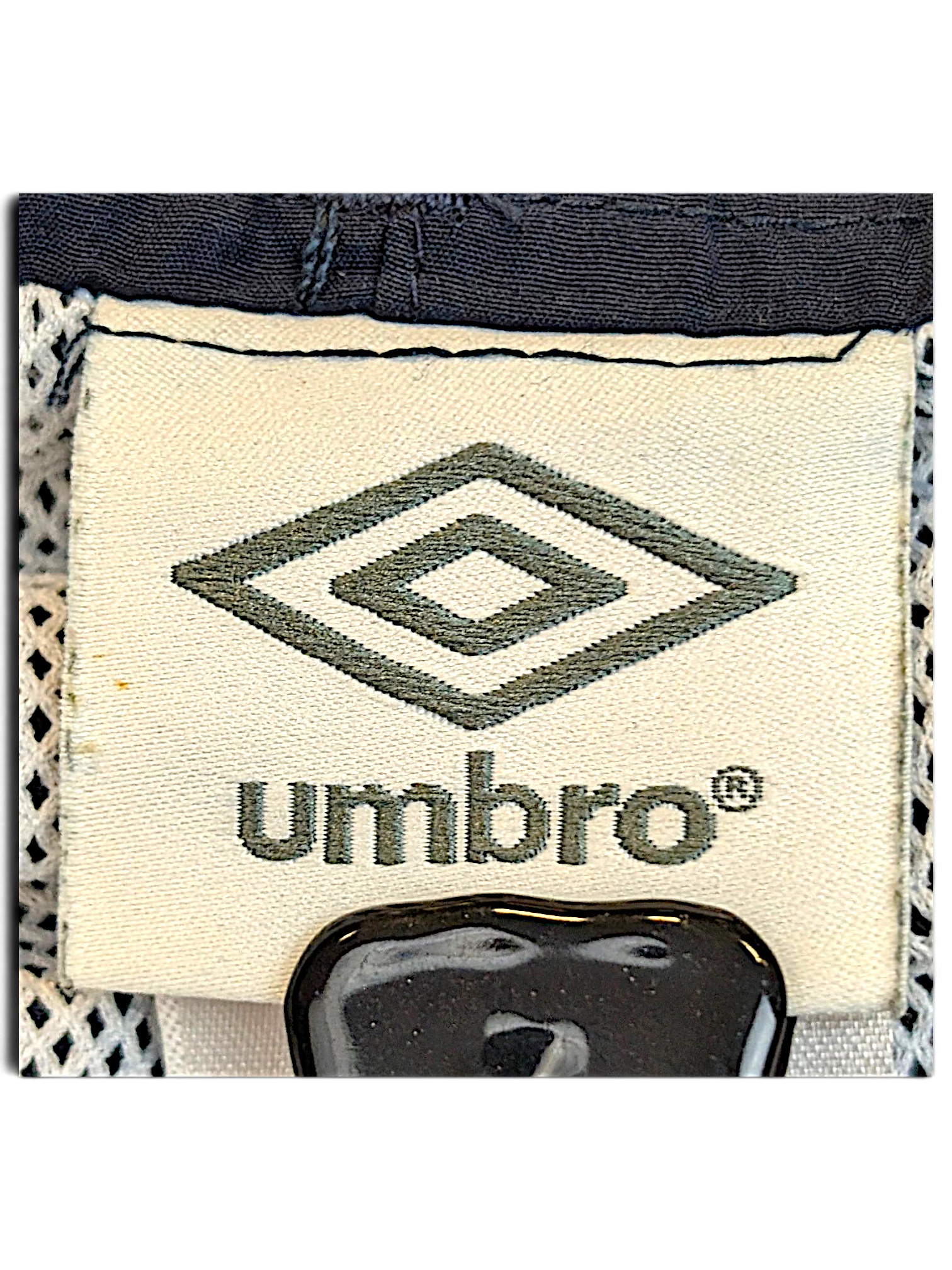JAKE & IPI Umbro brand label on navy and grey track pants with white mesh lining