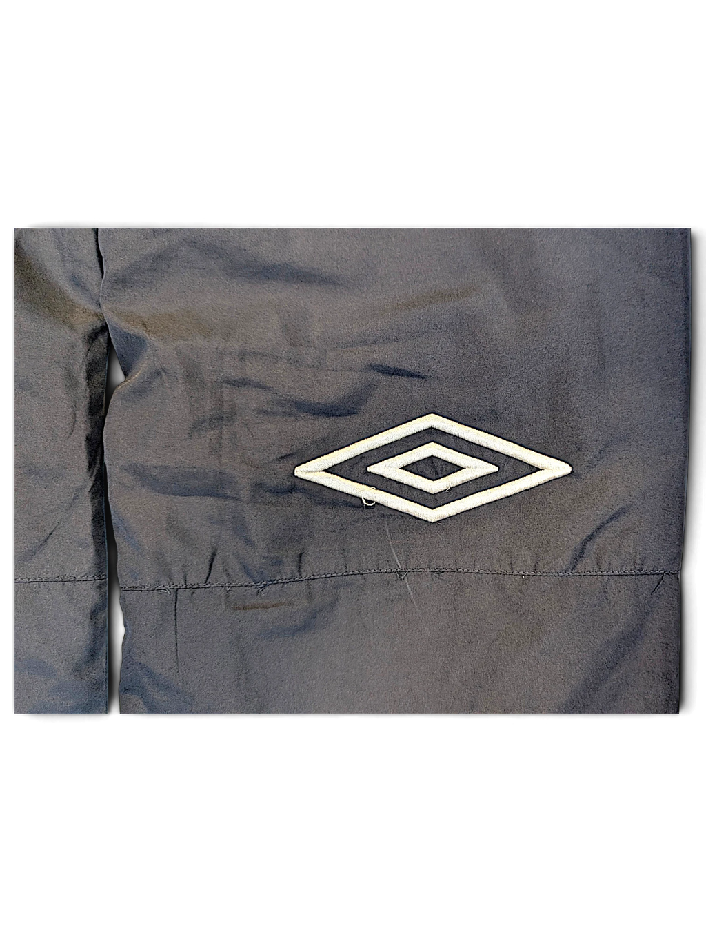 JAKE & IPI Umbro navy track pants featuring a white embroidered diamond logo detail on the fabric
