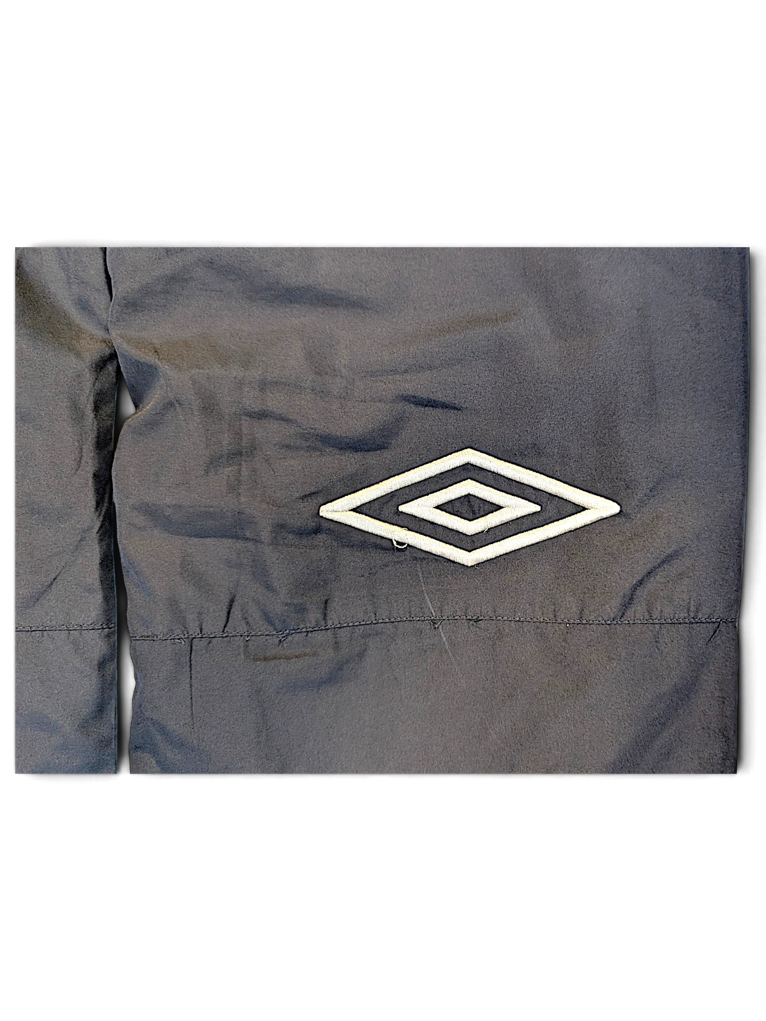 JAKE & IPI Umbro navy track pants featuring a white embroidered diamond logo detail on the fabric