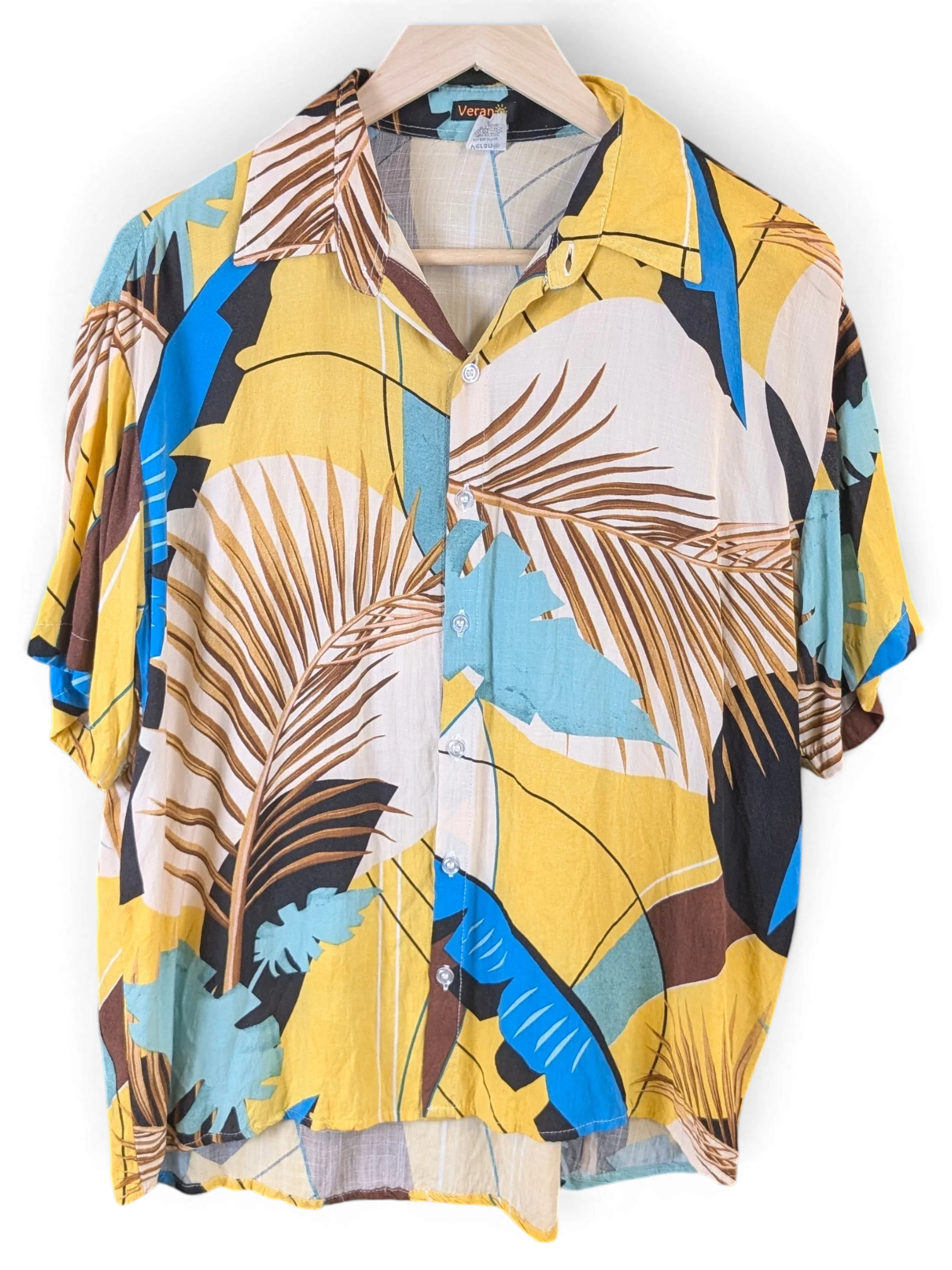 JAKE & IPI Veran Hawaiian shirt featuring a vibrant yellow, blue, and brown tropical palm leaf print on a hanger.