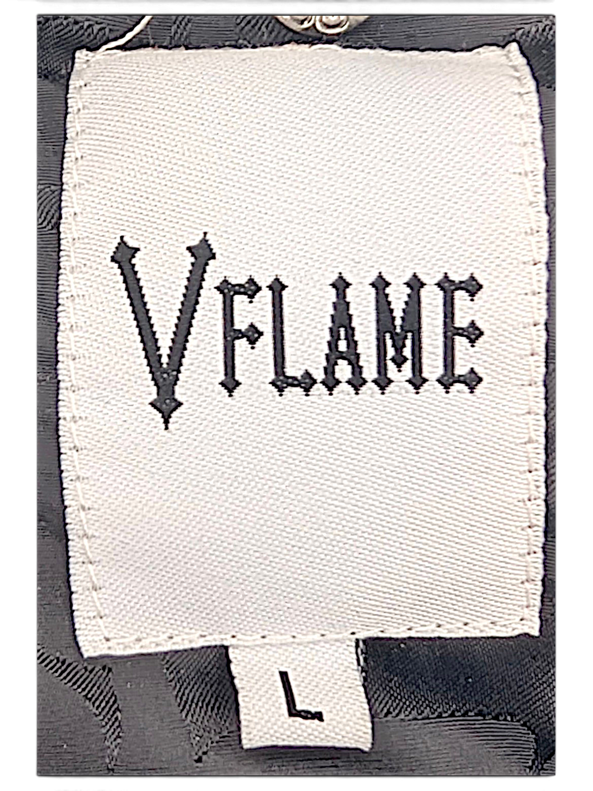 JAKE & IPI VFlame musta toppatakin tuotemerkki ja kokolappu, jossa näkyy goottilainen monogrammikuvioitu vuori.