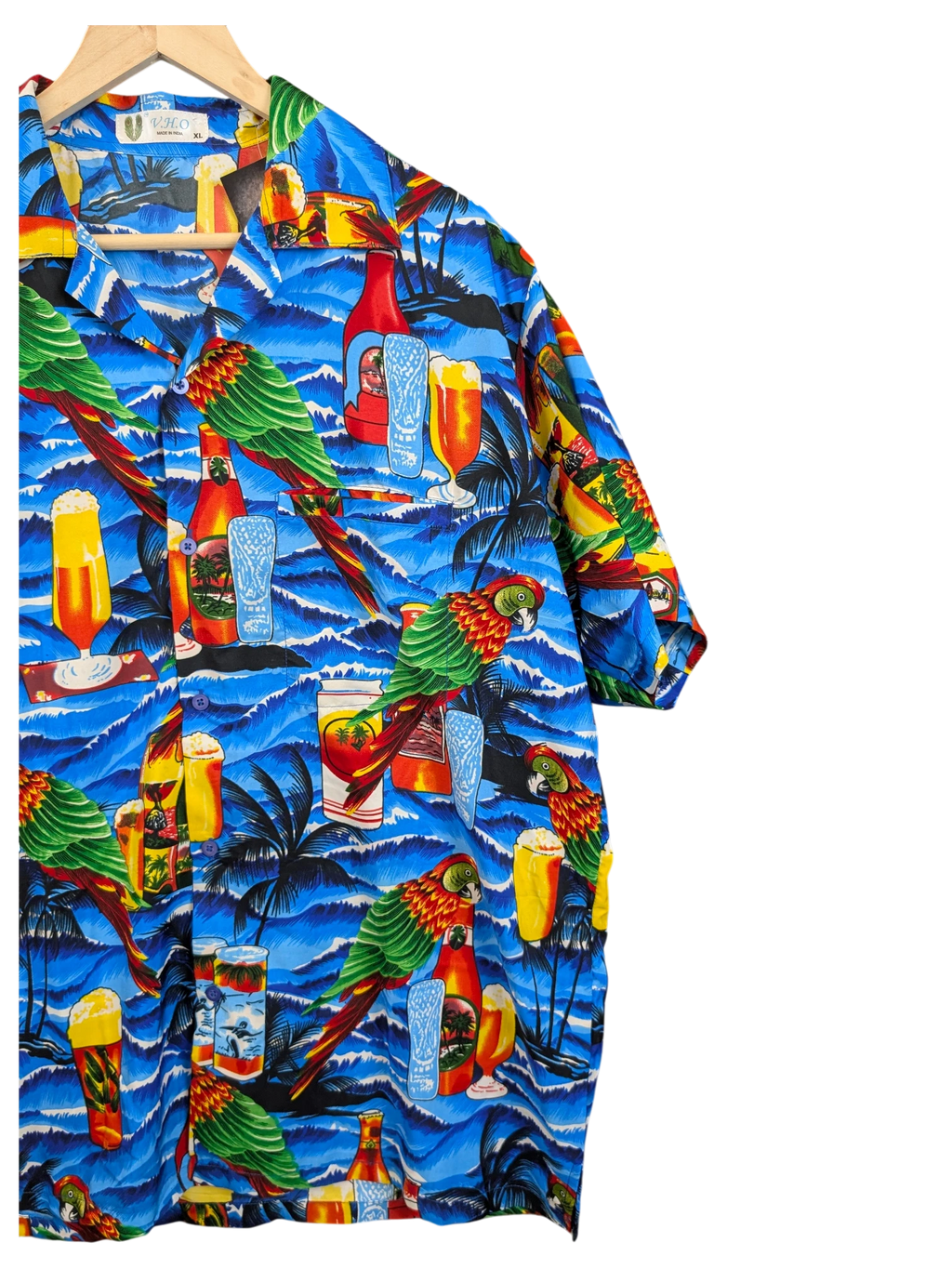 JAKE & IPI V.H.O Hawaiian shirt featuring a vibrant blue tropical print with parrots, palm trees, and beer glasses.