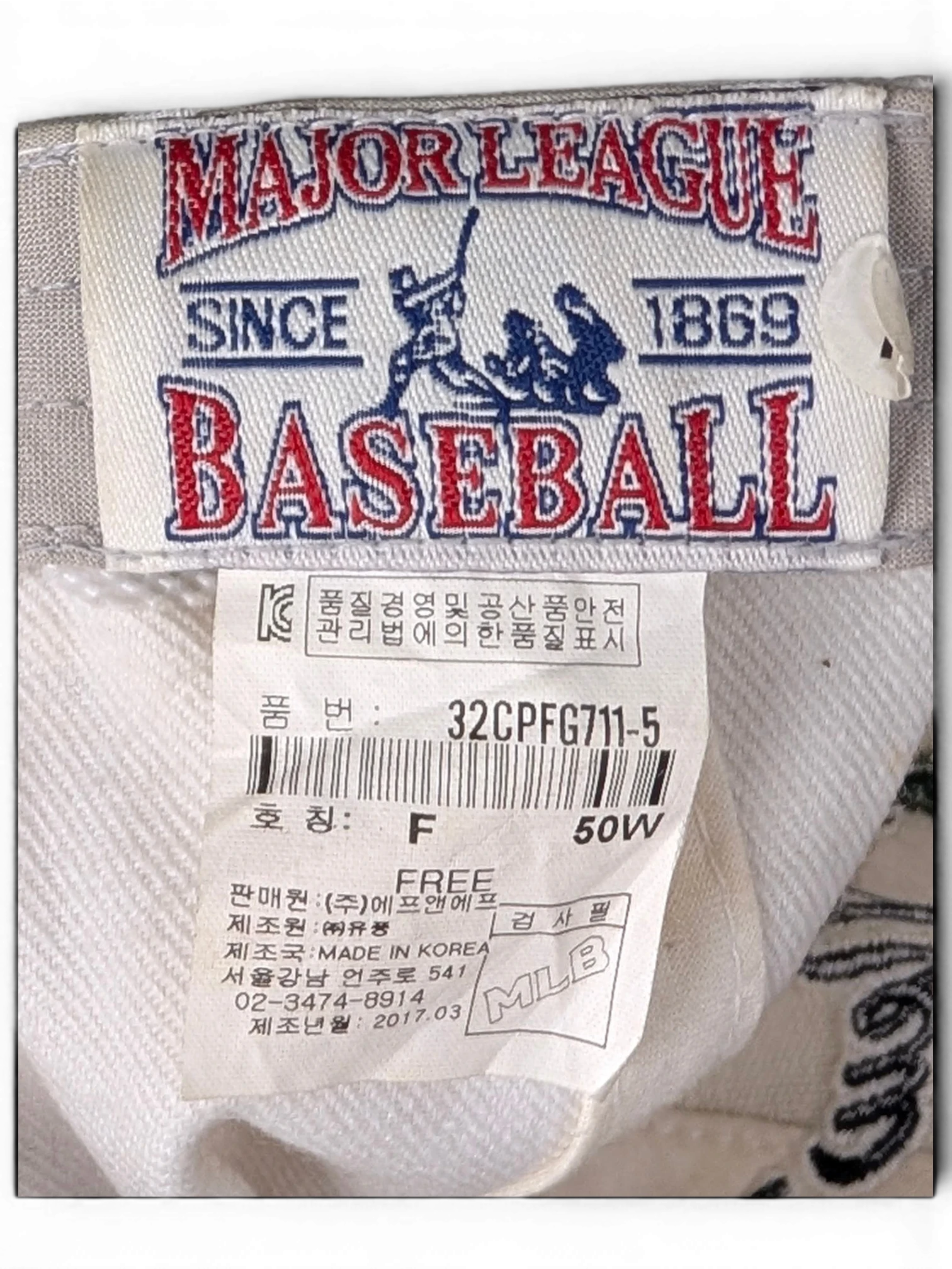 JAKE & IPI white baseball cap interior label with Major League Baseball branding and product details