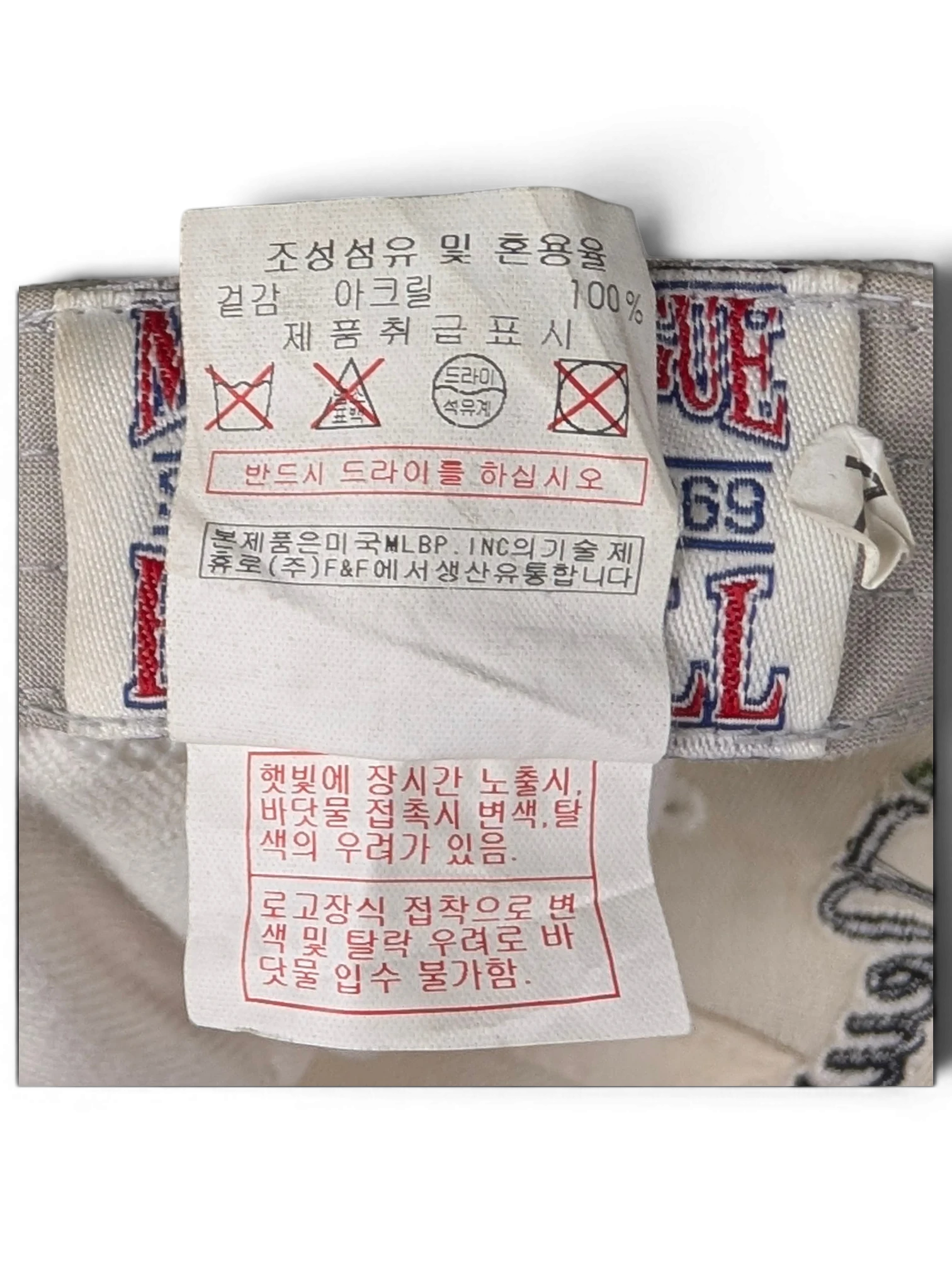 JAKE & IPI white cap interior care label with 100% acrylic composition details and washing instructions