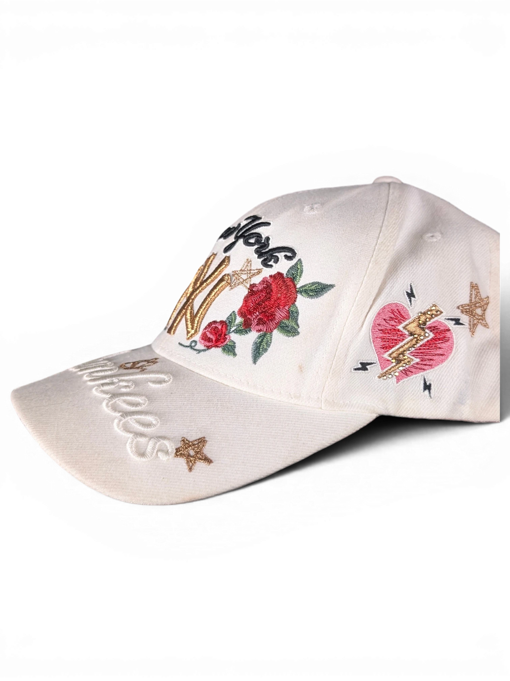JAKE & IPI white baseball cap featuring embroidered New York text, red roses, a heart, and gold star details.