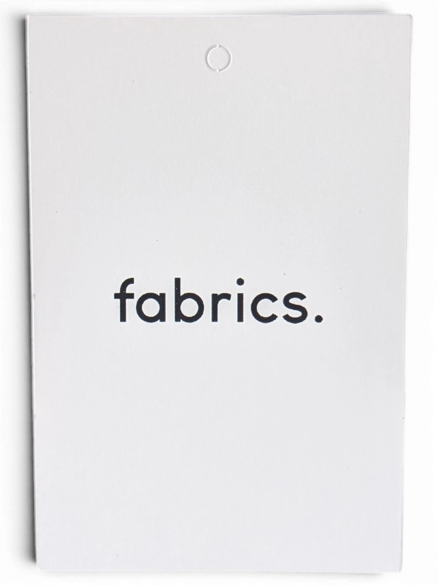 JAKE & IPI white product tag with fabrics. text printed in black, displayed against a dark background.