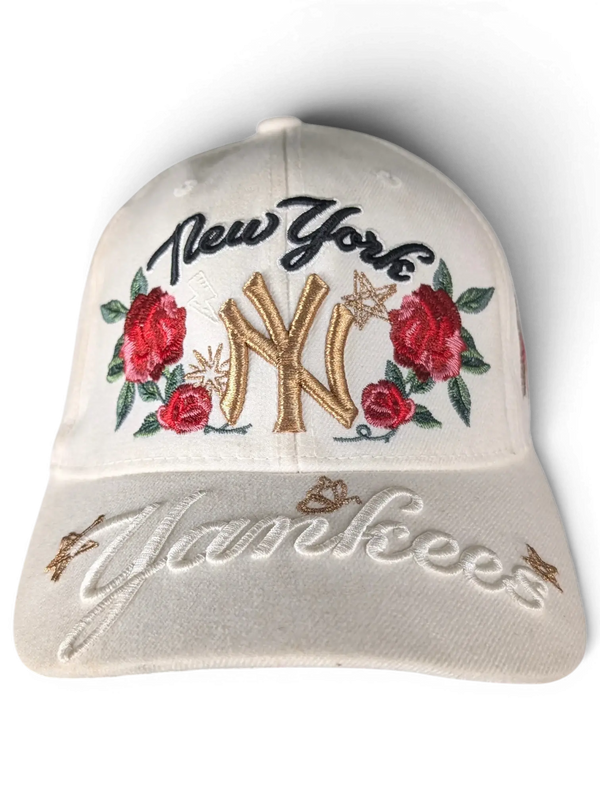 JAKE & IPI white New York Yankees cap featuring gold NY embroidery, red rose floral accents, and script lettering.