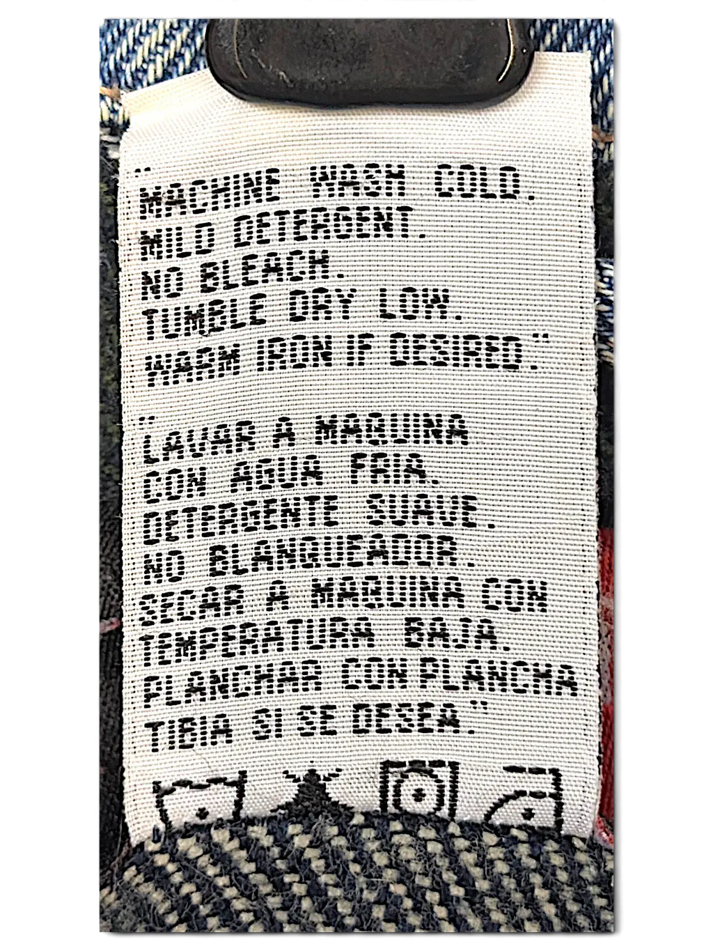 JAKE & IPI Wrangler denim jacket care label with washing instructions in English and Spanish on quilted lining
