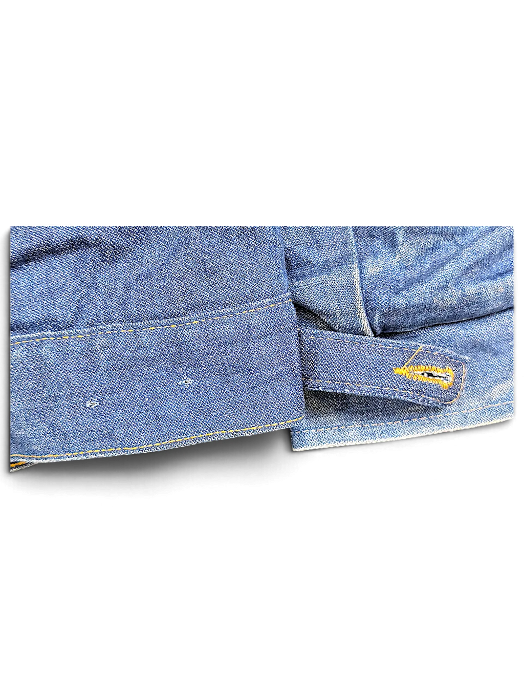 Close-up of the blue denim hem and adjustable button tab on a vintage JAKE & IPI Wrangler Sherpa jacket.