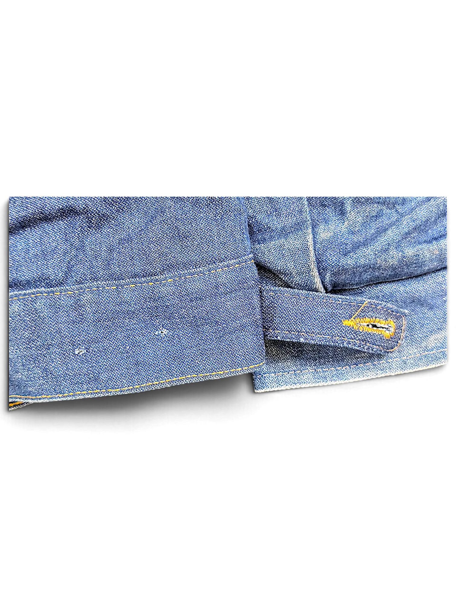 Close-up of the blue denim hem and adjustable button tab on a vintage JAKE & IPI Wrangler Sherpa jacket.
