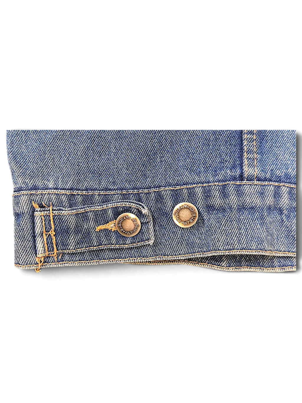 Close-up of the hem and metal button detail on a blue denim Wrangler Hero Denim Jacket from JAKE & IPI