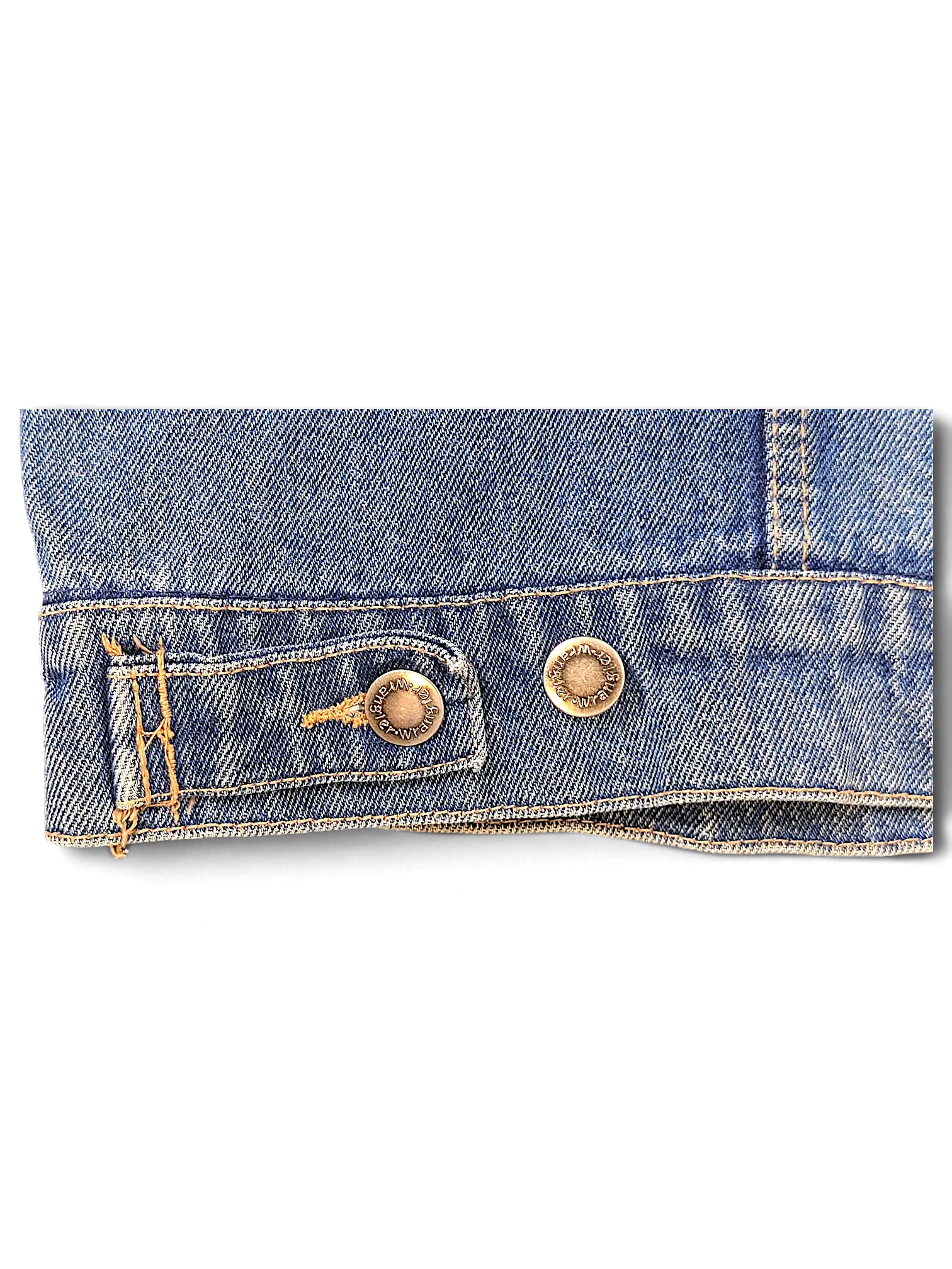 Close-up of the hem and metal button detail on a blue denim Wrangler Hero Denim Jacket from JAKE & IPI