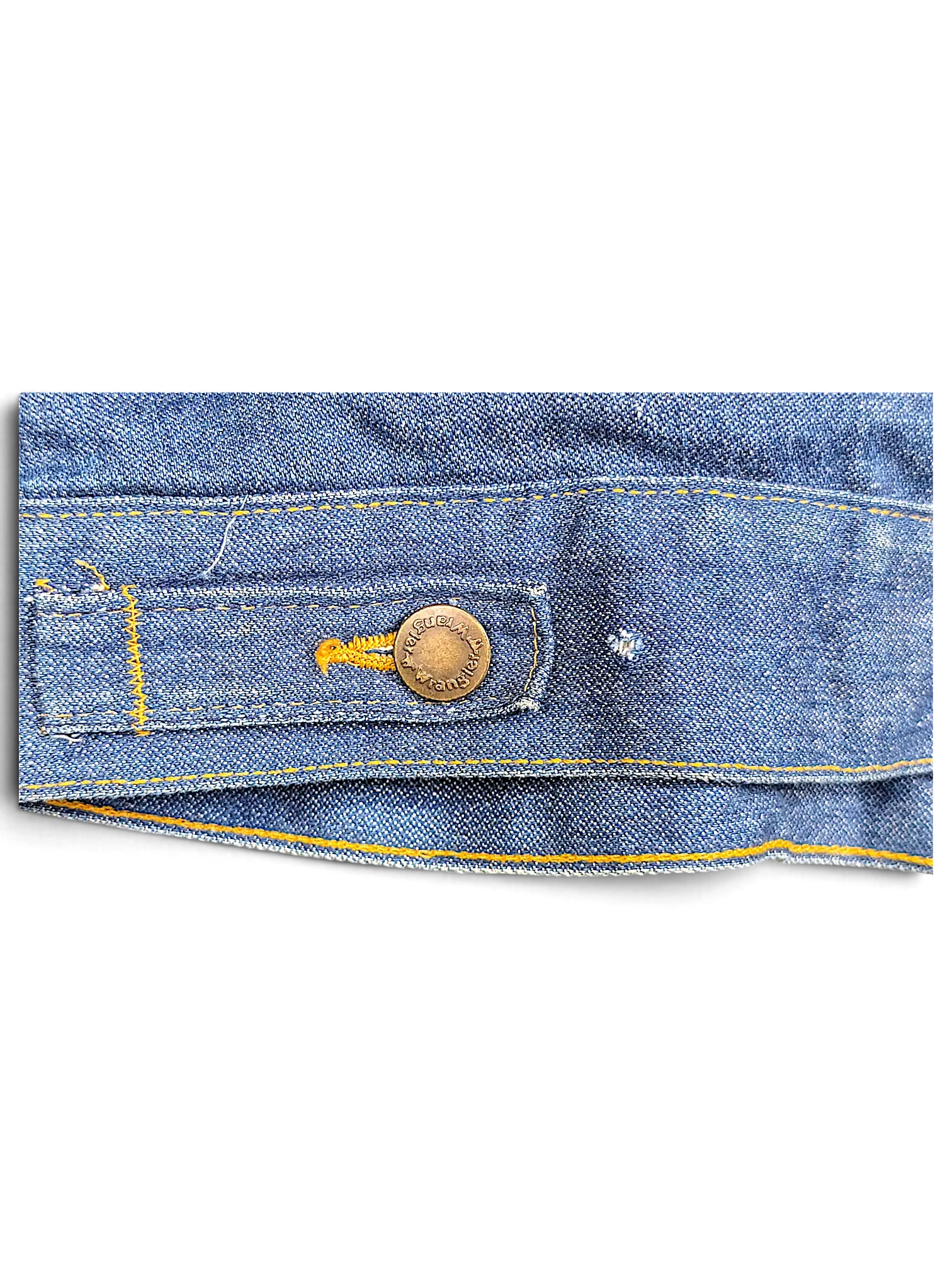 Close-up of a vintage blue denim Wrangler 80/90's Sherpa Jacket hem with a branded metal button by JAKE & IPI