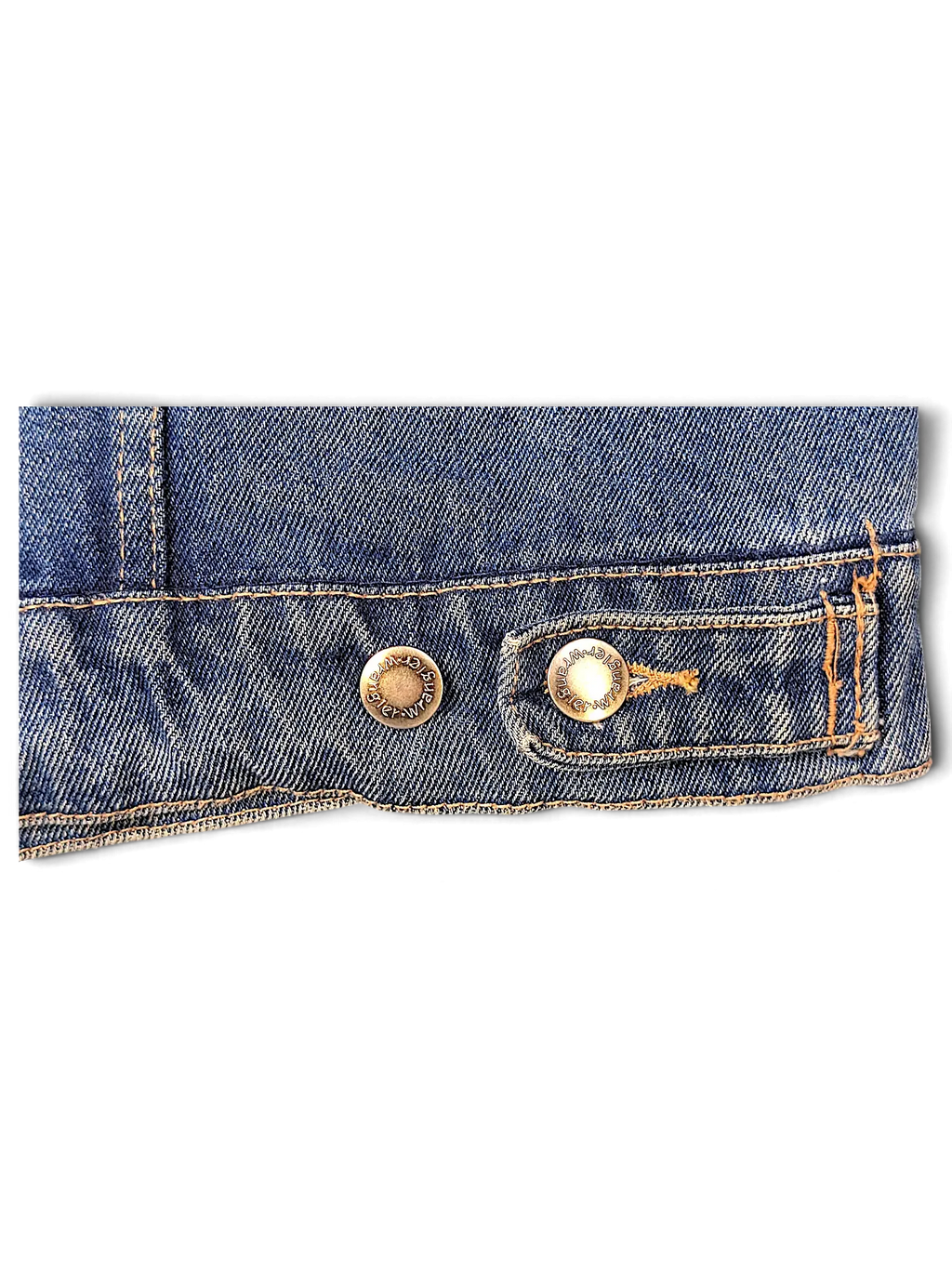 Close-up of the hem and brass buttons on a JAKE & IPI Wrangler Hero blue denim jacket with contrast stitching