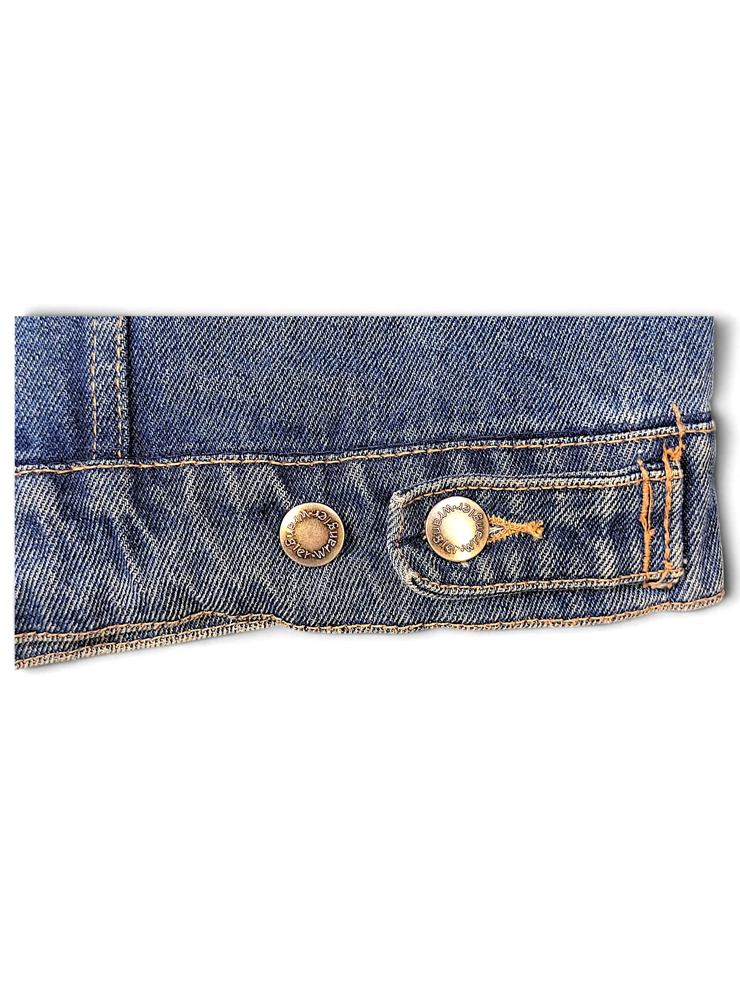 Close-up of the hem and brass buttons on a JAKE & IPI Wrangler Hero blue denim jacket with contrast stitching