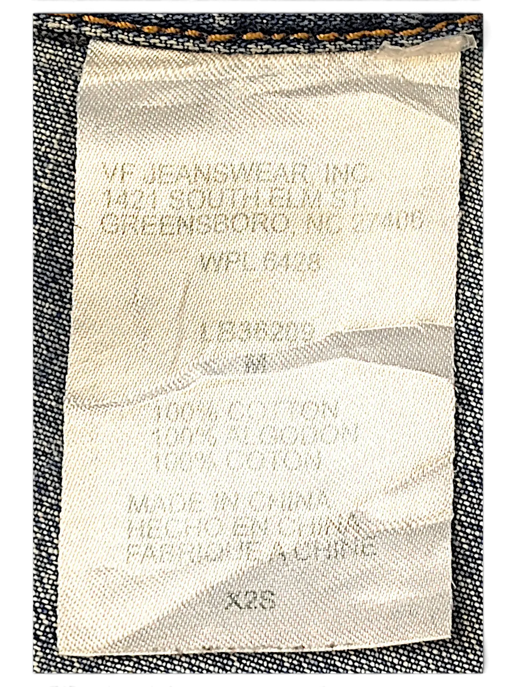 JAKE & IPI Wrangler blues denim jacket interior care label showing 100 percent cotton material composition