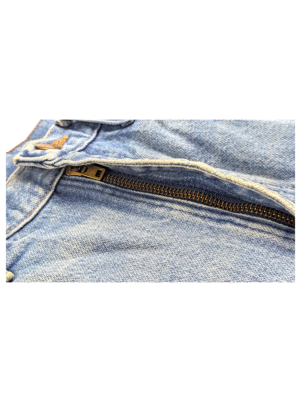 Close-up of the metal zipper and blue denim fabric on JAKE & IPI Wrangler bootcut jeans.