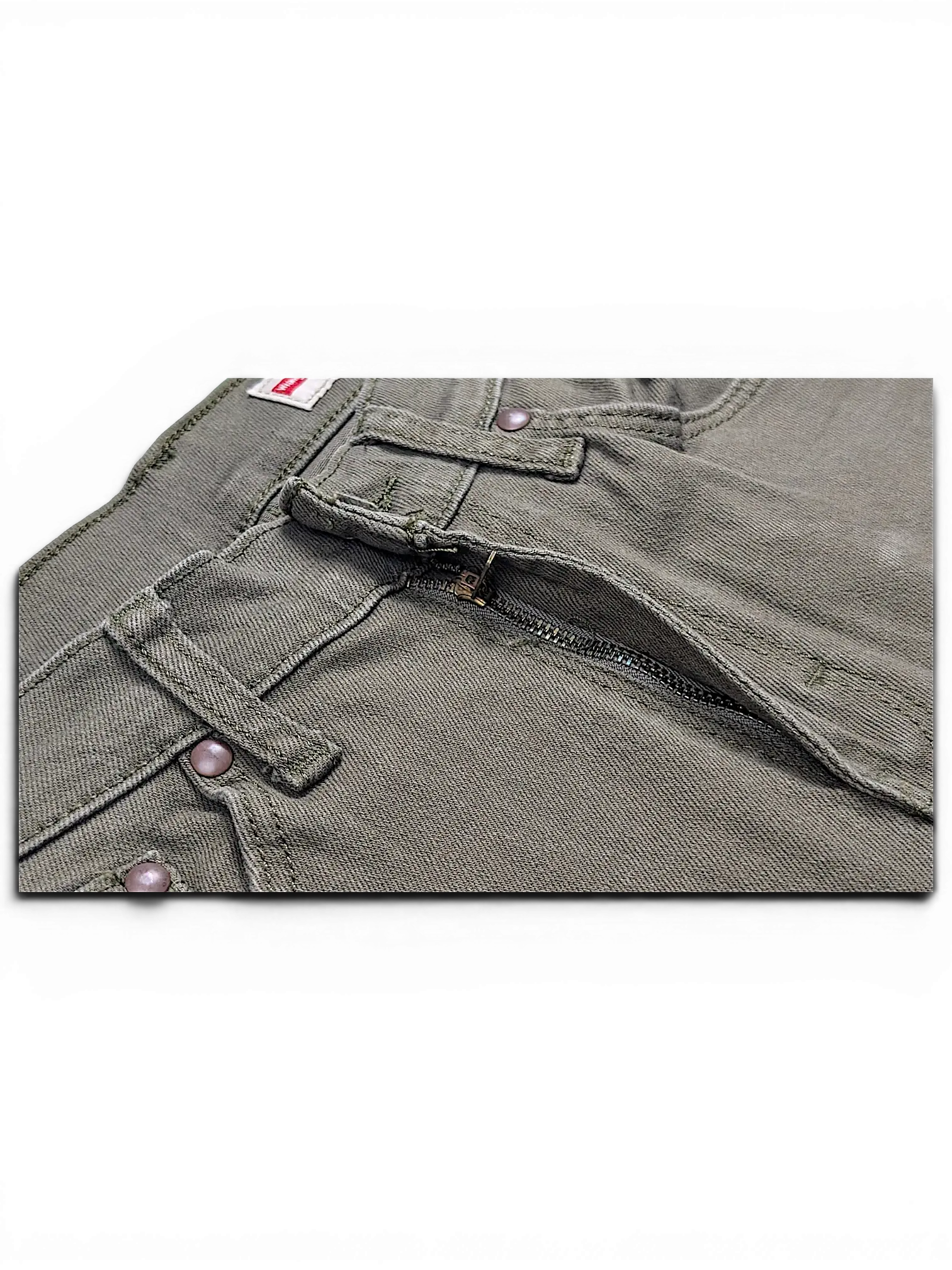 Close-up of JAKE & IPI Wrangler green athletic fit jeans featuring a metal zipper fly and reinforced stitching.