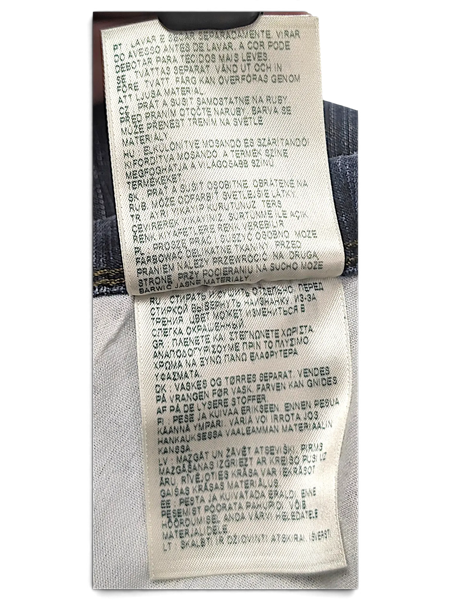 JAKE & IPI Wrangler jeans care instruction label with multi-language washing guidelines on white fabric tag