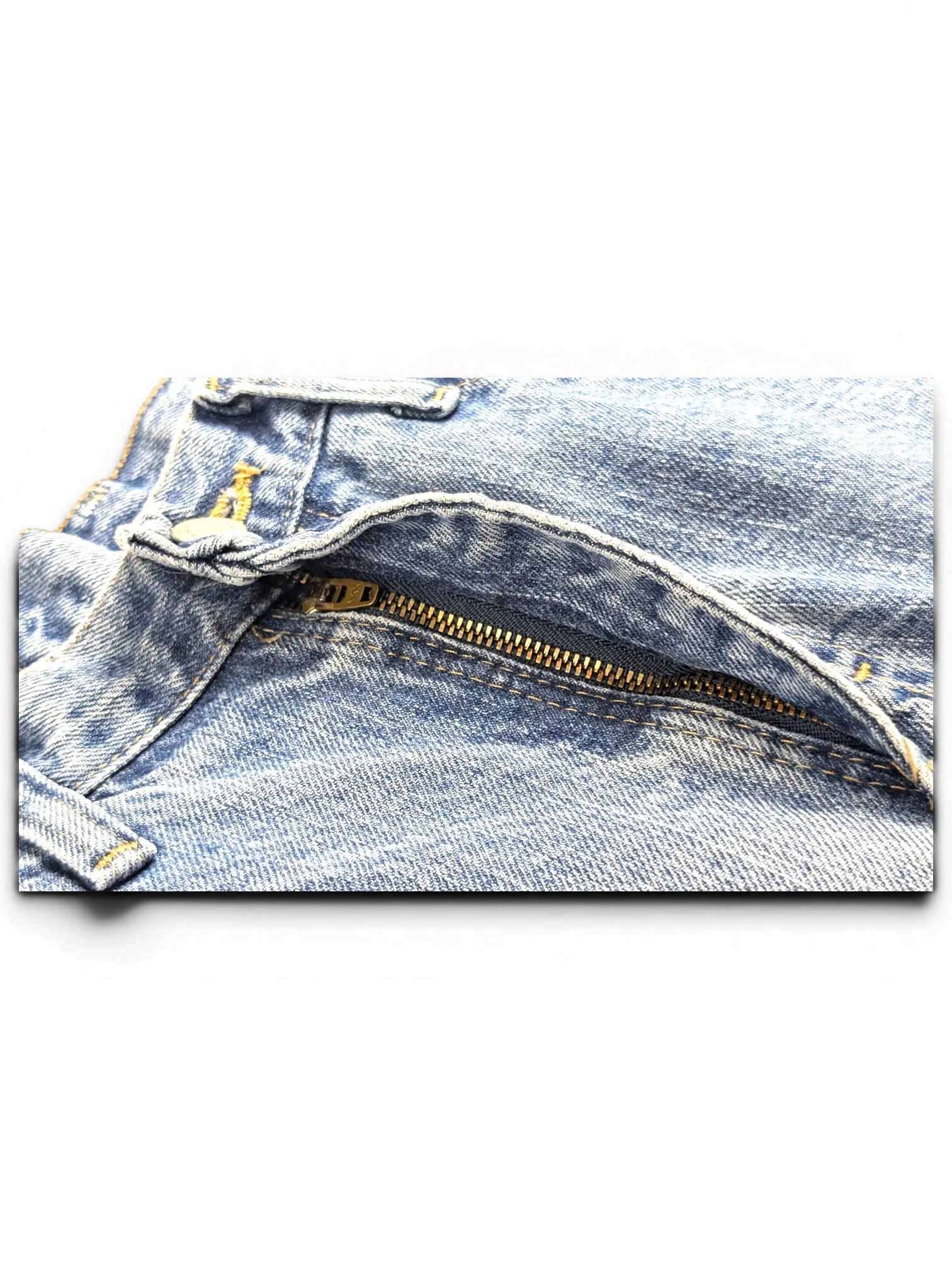 Close-up of JAKE & IPI Wrangler jeans featuring a blue denim fabric with a metal zipper fly and belt loops.