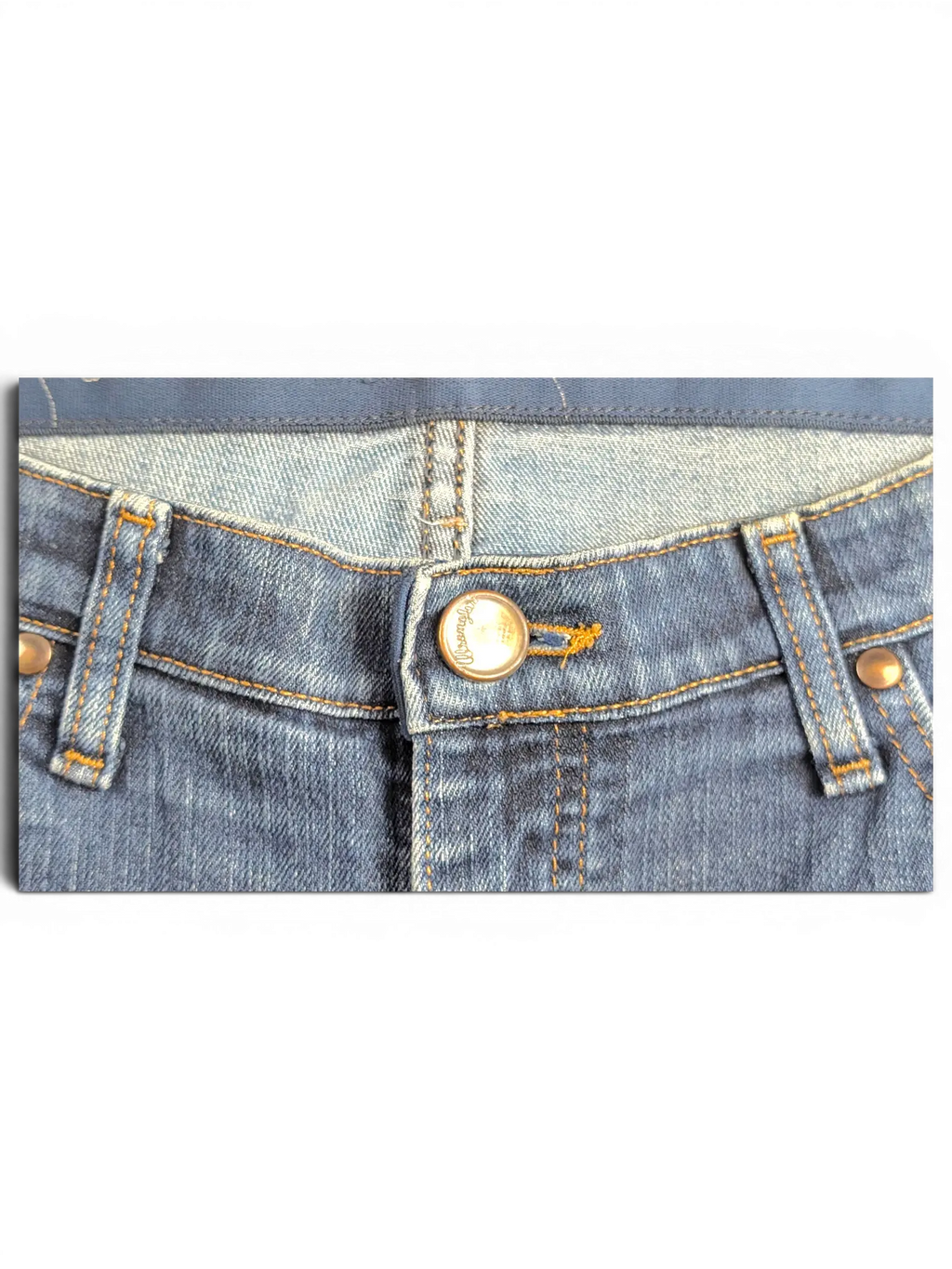 JAKE & IPI Wrangler Q-BABY blue denim jeans featuring a branded metal button and contrast stitching detail.
