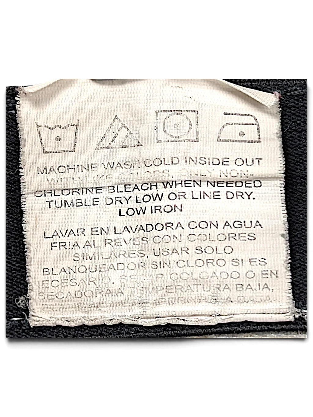 JAKE & IPI Wrangler Riggs Workwear pants care label with washing instructions in English and Spanish