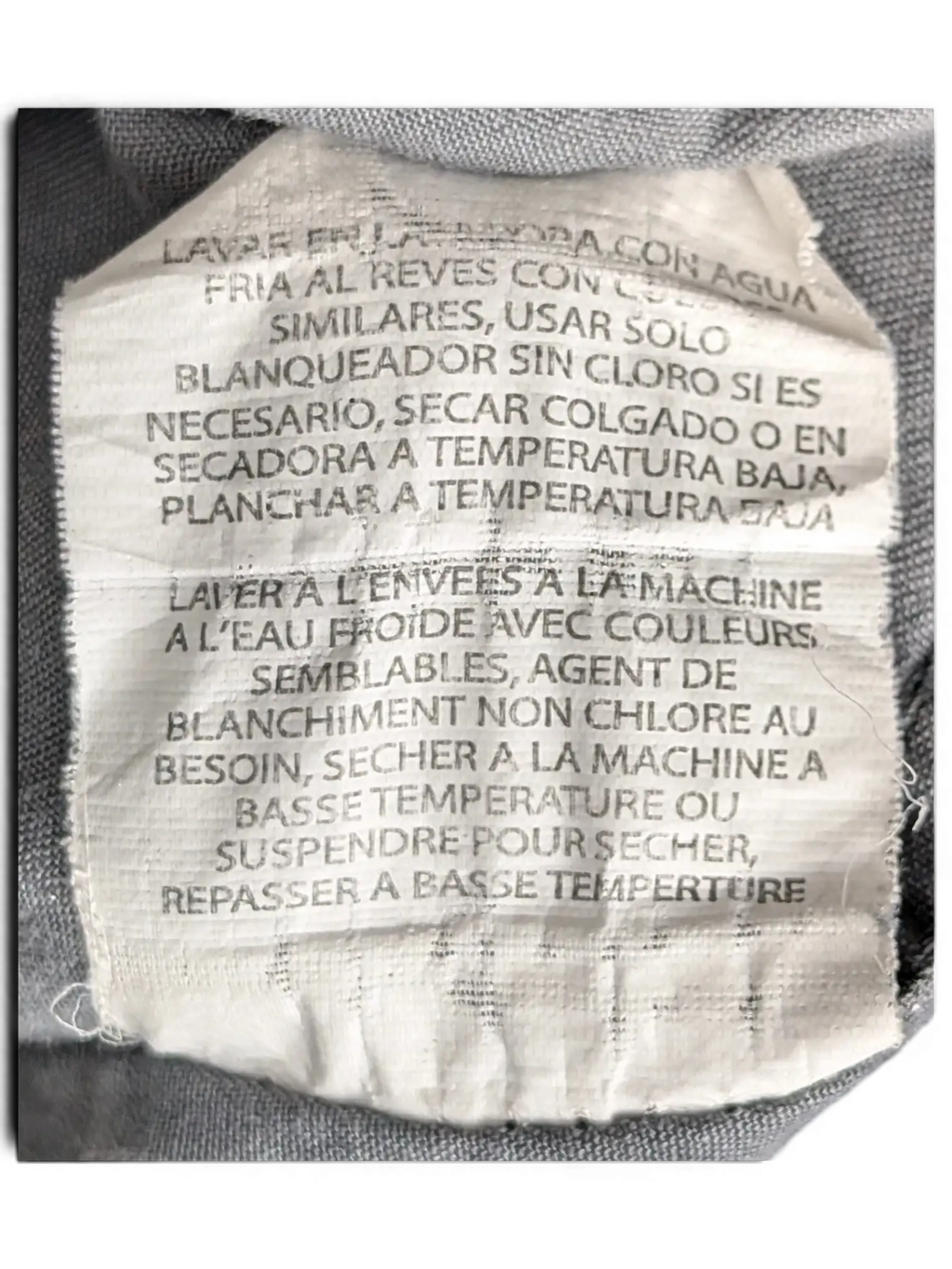 JAKE & IPI Wrangler grey utility shirt care label with washing instructions in English, Spanish, and French.