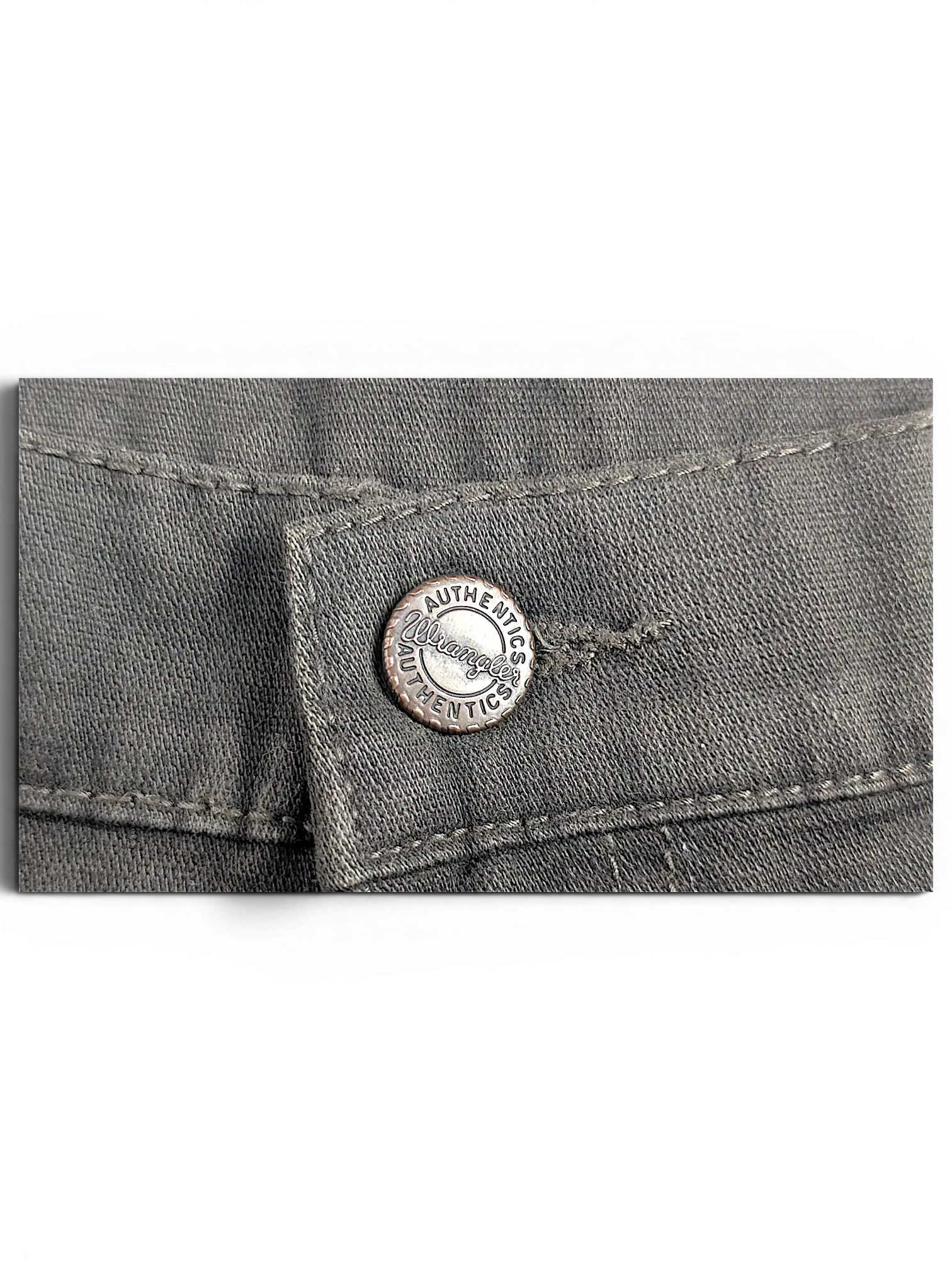 JAKE & IPI Wrangler Texas stretch pants featuring a branded metal button closure on grey denim fabric