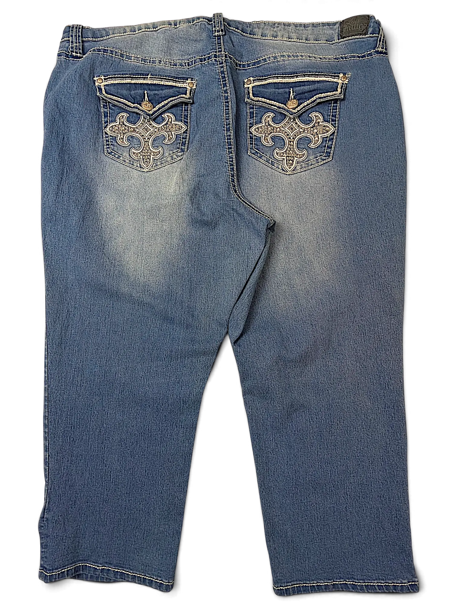 JAKE & IPI Love X Indigo Y2K jeans featuring back pockets with white embroidered scrollwork and button flaps.