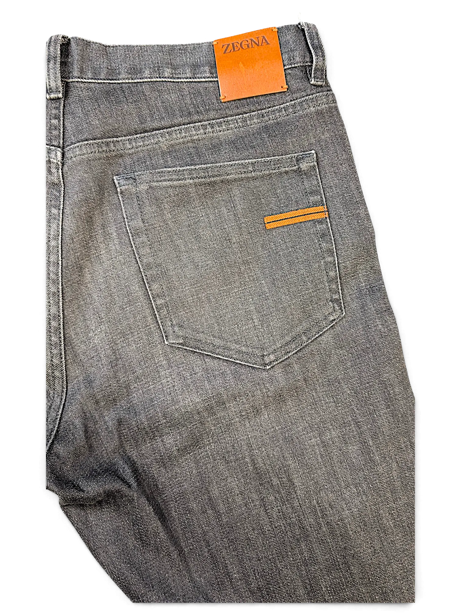 JAKE & IPI grey Zegna denim jeans featuring a leather brand patch and orange accent stitching on the back pocket.