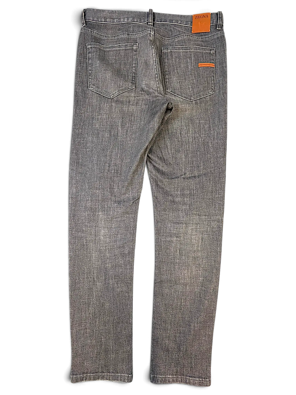 JAKE & IPI Zegna grey denim jeans featuring a leather back patch and orange accent stitching on the back pocket.
