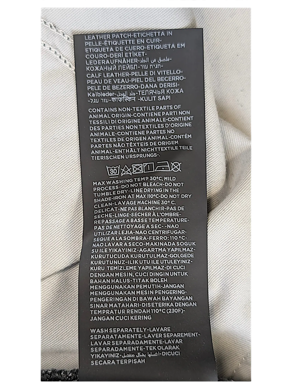 JAKE & IPI Zegna jeans interior care label with washing instructions in multiple languages and leather patch detail